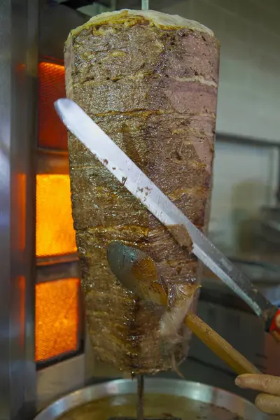 Geleneksel Türk et donörü veya shawarma için et kesen bir şefin yakın çekimi. Sokak yemekleri konsepti. İstanbul 'da et bağışçısı.