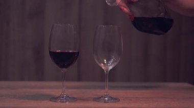 Boş şarap kadehinin üzerine dökülen kırmızı şarap akıntısı. Yüksek kalite 4k görüntü