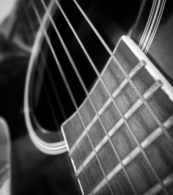 Siyah elektro-akustik gitar detayının siyah-beyaz fotoğrafı