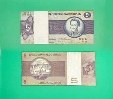 Brezilya Merkez Bankası 'ndan yeşil zemin üzerinde iki 5 cruzeiro banknotunun resmi. Notlarda bir adamın portresi, geometrik ayrıntılar ve bankanın değeri ve dağıtımı hakkında bilgiler yer alıyor..