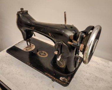 Vintage sewing machine in black and silver, with golden details, highlighting its elegance and history. A decor piece that evokes nostalgia and the art of sewing.