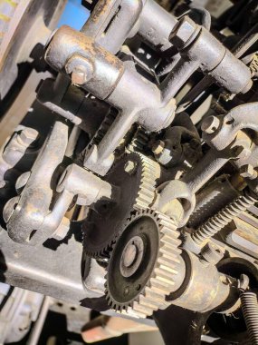 Yakın plan bir görüntü mekanik bir motorun karmaşık dişli ve bileşenlerini ortaya çıkarır. Yoğun ışık, metalik bitişleri ve demirin yıpranmış dokusunu vurguluyor. Bu da mühendislikte güç ve dayanıklılık hissi uyandırıyor..