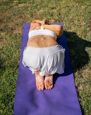 Yoga yaparken sakin ve sakin bir sahne, farkındalığı, rahatlığı ve bağlantıyı vurguluyor.