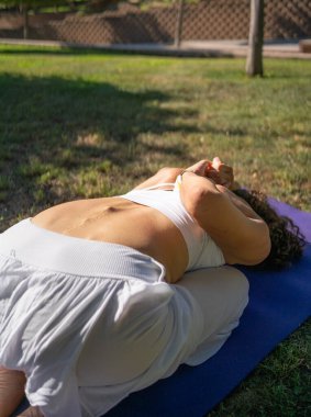 Dışarıda yoga yapan dingin bir kadın, doğası gereği huzur ve farkındalığın güzel anlarını yakalıyor.