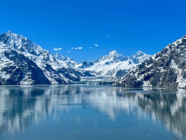 Buzul Körfezi Ulusal Parkı 'nın nefes kesen manzarası, karla kaplı tepelerin el değmemiş buzlu suları yansıttığı yer. Alaska 'nın el değmemiş güzelliğinin gerçek bir kanıtı..