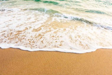 Sahilde deniz köpüğüyle birlikte doğa. Sahilde dalgalı bir arka plan. Deniz kenarında yaz tatili