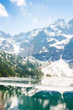 Baharda Polonya 'nın Tatra dağlarında göl manzarası. Alp manzarası mavi gökyüzünün altında. Morskie Oko 'da açık hava macerası ve tatil sezonu