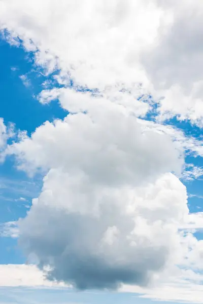 Mavi gökyüzünde beyaz kümülüs bulutları. Parlak güneşli bir gün. Sakin bir ortam.
