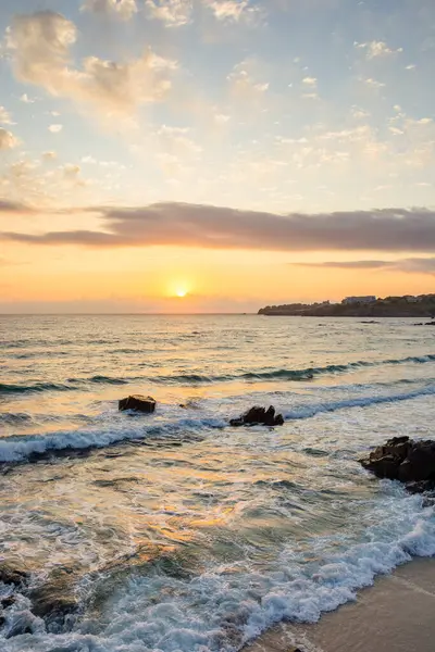 Yazın gün doğumunda deniz sahili manzarası. Gökyüzündeki güneş