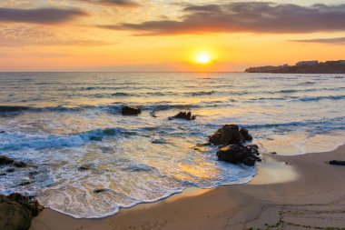Sahilde güneşin doğuşu muhteşem bir gökyüzüyle. Karadeniz 'de yaz kaçamağı duvar kâğıdı. Tatil sezonu. Sakin su ve turuncu bulutlar. İspanya seyahat geçmişi. Güneşli tatil deniz manzarası. Güneş ufukta görünüyor