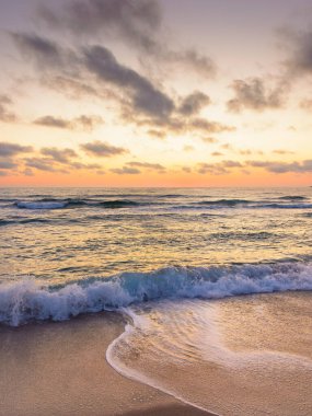Deniz dalgası şafakta kumsala değecek. Sozopol 'da yaz tatili. Doğa, parlak turuncu gökyüzü ve kara bulutlar altında huzur dolu rüyalar. Sakin suyu olan deniz manzarası ve rahatlama havası.