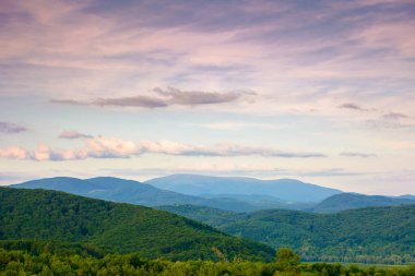 Akşamüstü gökyüzünün altında dramatik bulutlarla dolu bir dağ manzarası. Yazın güzel Karpatya kırsal manzarası. resimsi görünüm