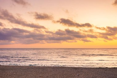 Yazın sahilde gel-git olur. Gökyüzünde turuncu parıltı ve şafak vakti bulutlar. Güneş doğmadan önce güzel bir doğa durumu. Altın saatte dramatik hava. Zen kadife sezon tatili