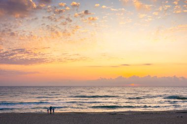 Yazın denizde gün doğumu, ufukta güneş ve bulutlar. Şafakta sakin bir yolculuk. dramatik hava