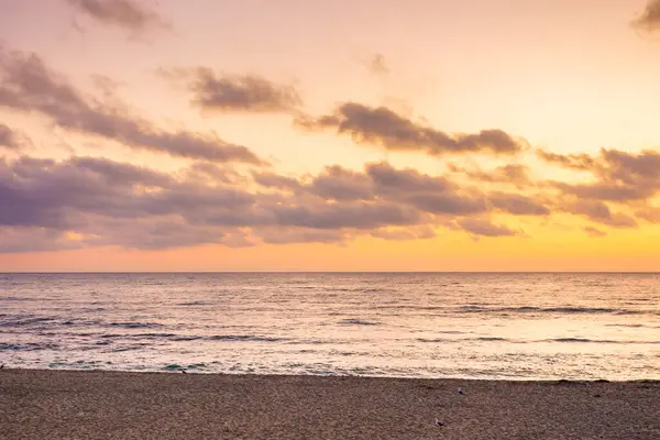 Yazın sahilde gel-git olur. Gökyüzünde turuncu parıltı ve şafak vakti bulutlar. Güneş doğmadan önce güzel bir doğa durumu. Altın saatte dramatik hava. Zen kadife sezon tatili