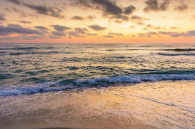 Deniz dalgası şafakta kumsala değecek. Sozopol 'da yaz tatili. Doğa, parlak turuncu gökyüzü ve kara bulutlar altında huzur dolu rüyalar. Sakin suyu olan deniz manzarası ve rahatlama havası.