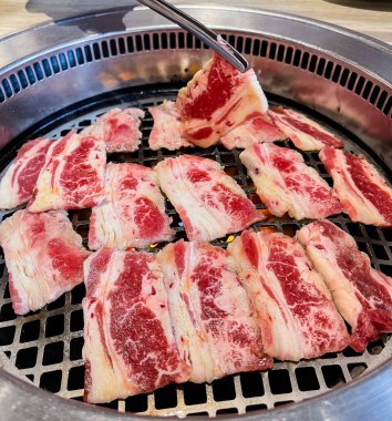 Lezzetli çiğ et dilimleri ızgarada pişiriliyor.