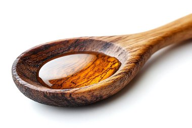 Balla dolu ahşap kaşığın yakın plan görüntüsü yapışkan sıvının berraklığını ve rengin derinliğini vurguluyor. Kaşık ahşap tanecikli kırsal cazibe katıyor..