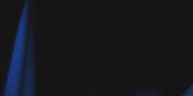 Koyu renkli ve kumlu bir görüntü. Sol alt köşeden çıkan mavi ışık demeti siyah arkaplana karşı bir değişim etkisi yaratıyor..