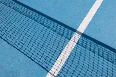Mavi zeminde tenis ağı ve beyaz şerit. Tenis kortundaki tenis ağının gölgesi. Spor konsepti