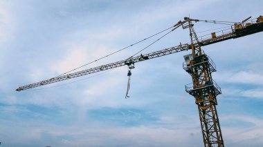 İHA 'dan yakalanan bulutlu bir gökyüzüne karşı inşaat alanında kule vinci.