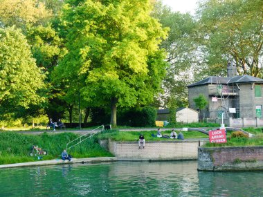 Cambridge, Cambridgeshire / Birleşik Krallık - 11 Mayıs 2025: Jesus Green in the evening. İnsanlar oturur, yürür ve dinlenir. Bahar ve Yaz.