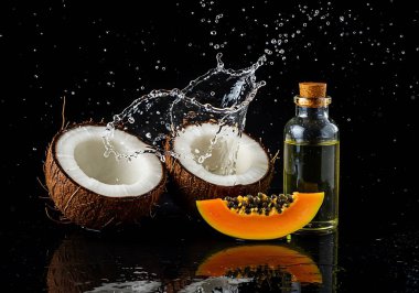 Dinamik bir su sıçraması ve parlak bir papaya dilimleri ile sanatsal bir şekilde sergilenen taze hindistan cevizlerinin ferahlatıcı görüntüsüne kapıl. Bu makro, yakın çekim bir şişe organla vurgulanmış tropik meyvelerin güzelliğini gözler önüne seriyor.