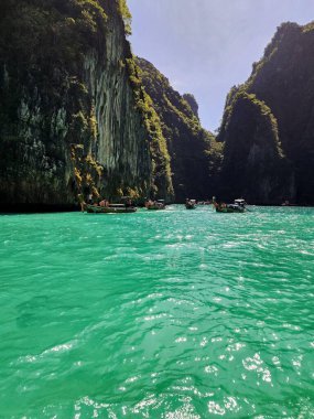 Yeşil suları ve tekneleri olan yemyeşil bir manzara Tayland 'da paradisial bir sahilde.