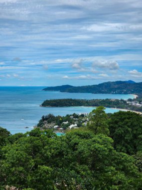 Güneş Promthep Burnu 'ndan (Phuket, Tayland) batıyor. Durgun denizin üzerindeki gökyüzünü botlarla turuncuya boyuyor. 