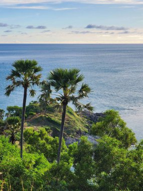 Güneş Promthep Burnu 'ndan (Phuket, Tayland) batıyor. Durgun denizin üzerindeki gökyüzünü botlarla turuncuya boyuyor. 