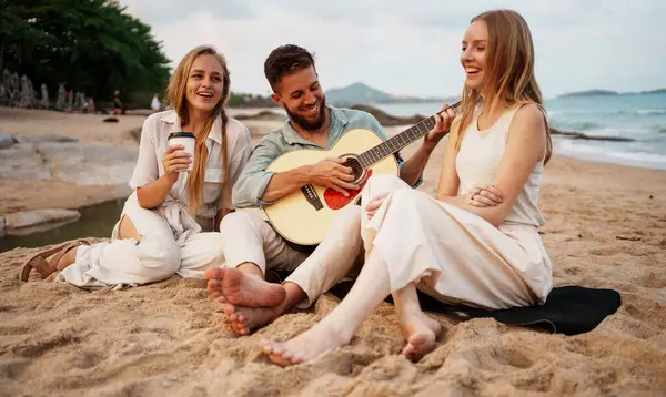 Kaygısız bir grup genç arkadaş plajda bir yaz gününün tadını çıkarıyor. Bir adam akustik gitar çalarken, diğerleri yakınlarda oturuyor, gülümsüyor, konuşuyor ve güneşin altında sırılsıklam oluyor. Otantik gençlik yaşam tarzı, özgürlük ve plaj titreşimlerini yakalar.