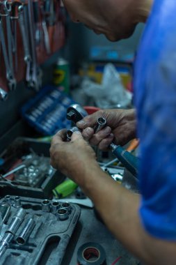 Atölyedeki tezgahta aletleri olan bir tamircinin yakın çekimi