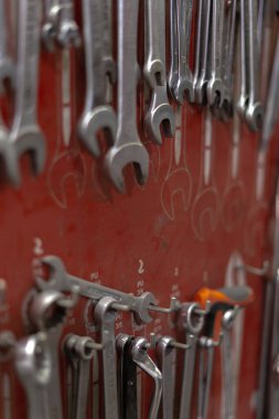 Atölyede kırmızı duvarda düzenlenmiş anahtarlar ve araçlar