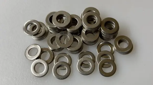 Beyaz arka planda bir sürü somun ve cıvata var.