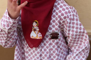 Valencia, İspanya, 16 Mart 2024, Valencia 'da Fallas Festivali' ni kutlamak için, üzerinde Fallerita ve desenli bir gömlek bulunan kırmızı eşarplı geleneksel Fallas kıyafeti giyen bir adam..