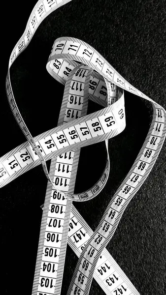 Siyah zemin üzerinde granit desenli beyaz mezura..