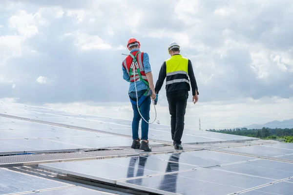 기술자들은 지붕에 태양계의 작동을 확인하고 에너지를 보존하기 에너지 에너지 생산을 — 스톡 사진