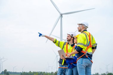 Mühendis teftişi ve inceleme rüzgar türbinleri çiftliklerinde elektrik enerjisi üretmek için çalışıyor..