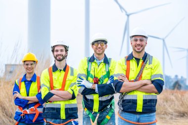 Yenilenebilir enerji çiftliğinde çalışan mühendis açık havada rüzgar türbinlerinin çalışmasını kontrol ediyor..