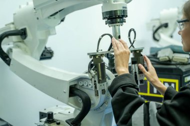 Bilgisayar Bilimi ve Robot Endüstrisi Konseptinde modern robot kolunu, Modern Ekipman ve Yeni Çağ 'da programlamak için dizüstü bilgisayar kullanan mühendis.