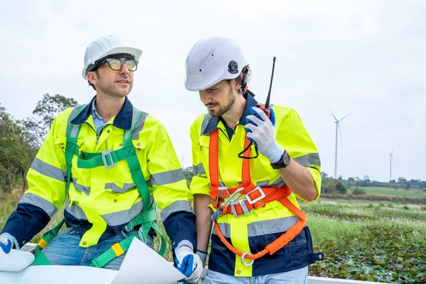 利用替代绿色能源在田里寻找和检查风力涡轮机的工程师 — 图库照片