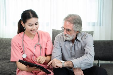 Hemşire ve kıdemli bir adam huzurevinde dijital tablet, yaşlı hizmetleri ve yaşlı bakım konsepti kullanıyor..