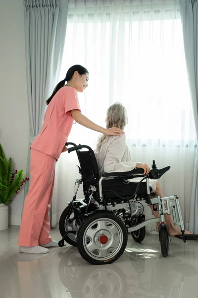 友爱的护士扶着一位老太太 享受着祥和的时光 — 图库照片