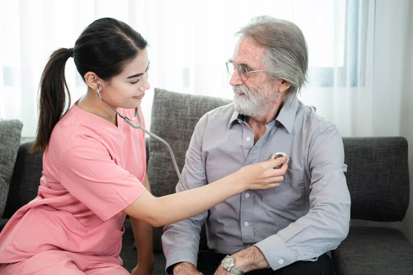 护士使用听诊器检查家中或疗养院的心脏老年人 家庭护理及医护护理的概念 — 图库照片