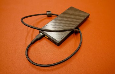 Kyiv, Ukrayna - 28 Mart 2025: Kahverengi zemin üzerinde USB tip C kablo ile 10.000 mAh güç bankası