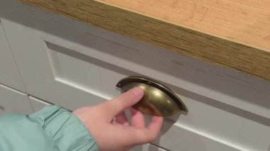 Bir çocuğun eli mezbahada bir çekmeceyi açar.