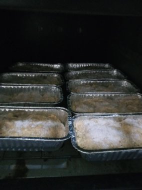 Fırında birkaç somun ekmek pişiriliyor, her biri ayrı folyo çarşaflarda. Ekmeğin yüzeyi biraz çıtır çıtır görünüyor. Bu da geleneksel bir fırın ortamında kısmen pişirildiklerini gösteriyor..