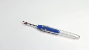 Giysilerdeki dikişleri çıkarmak için biçerdöver ya da deşici dikmek, beyaz arkaplanda tek başına izole edilmiş.