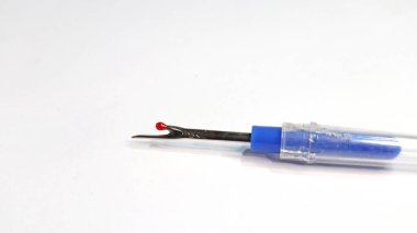 Giysilerdeki dikişleri çıkarmak için dikişçi ya da deşici dikiyorum. Beyaz arka planda izole edilmiş dikiş yırtıcısı.