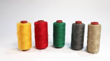 Dikey olarak dizilmiş çeşitli dikiş ipliklerinin izole edilmiş bir çekimi, canlı renklerini sergiliyor. Bu resim, el yapımı veya tekstil temalı projeler için ideal olan dikiş malzemelerinin çeşitliliğini ve dokusunu yakalar